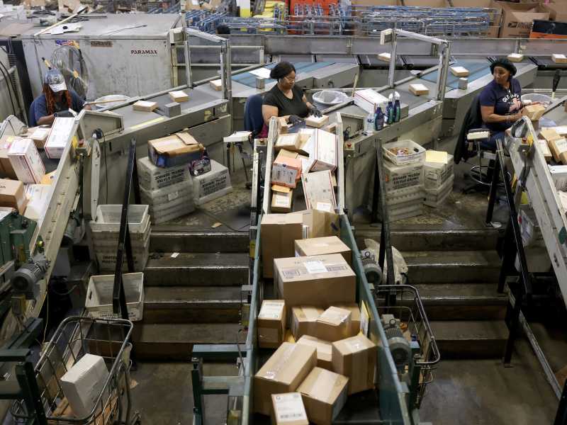 Addetti del servizio postale statunitense smistano i pacchi al Royal Palm Processing and Distribution Center di Opa Locka, Florida (Joe Raedle/Getty)&nbsp;<br />