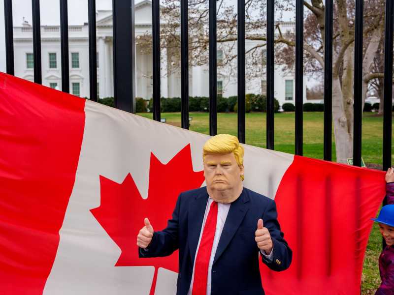 Un uomo con la maschera di Trump davanti alla Casa Bianca (foto di Andrew Harnik/Getty Images)&nbsp;<br />