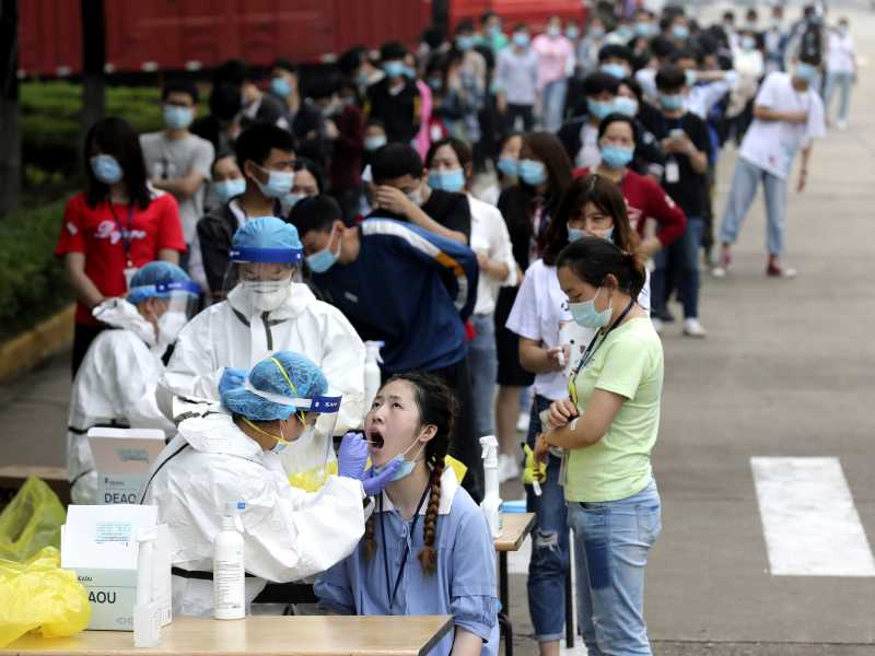 Test anti Covid-19 in una strada di Wuhan, in Cina, oltre un anno dopo lo scoppio della pandemia (foto Ap/LaPresse) <br />