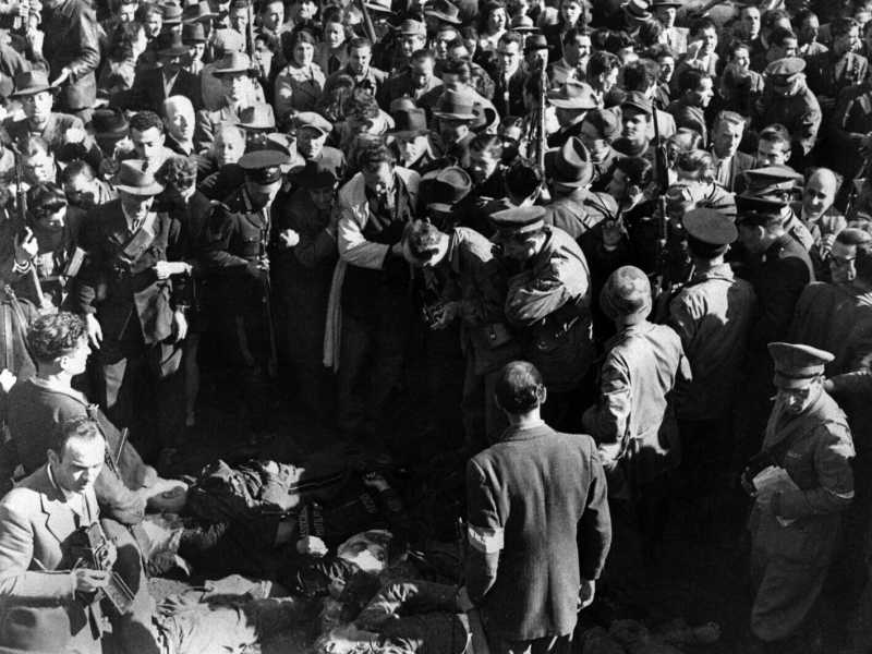 Milano, Piazzale Loreto, 25 aprile 1945: i cadaveri di Mussolini, di Claretta Petacci e di alcuni gerarchi fascisti tra una folla di curiosi e fotografi (LaPresse)&nbsp;<br />