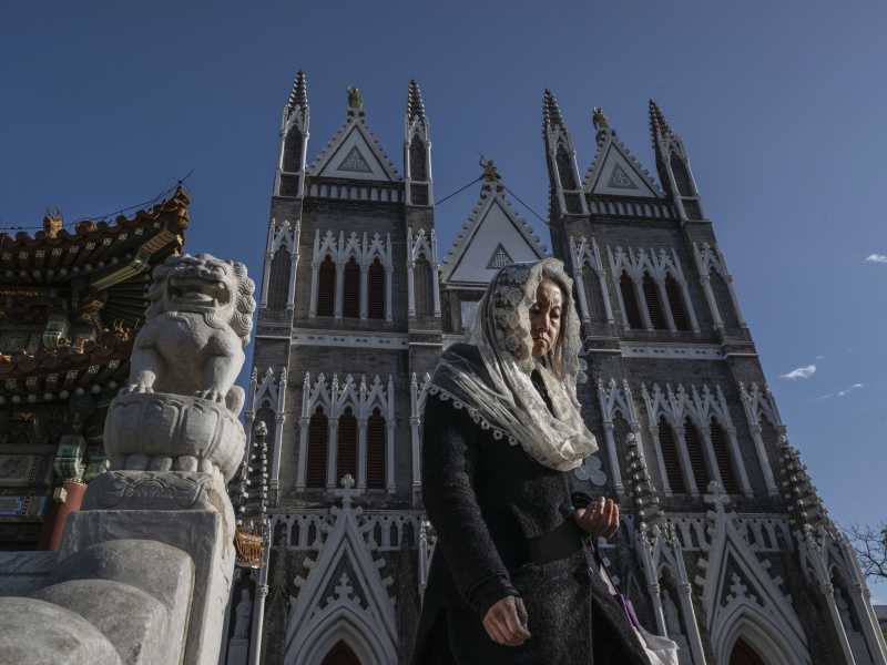 A Christian worshipper leaves a Sunday mass at the Xishiku Catholic Cathedral in Beijing (Kevin Frayer/Getty Images) <br />