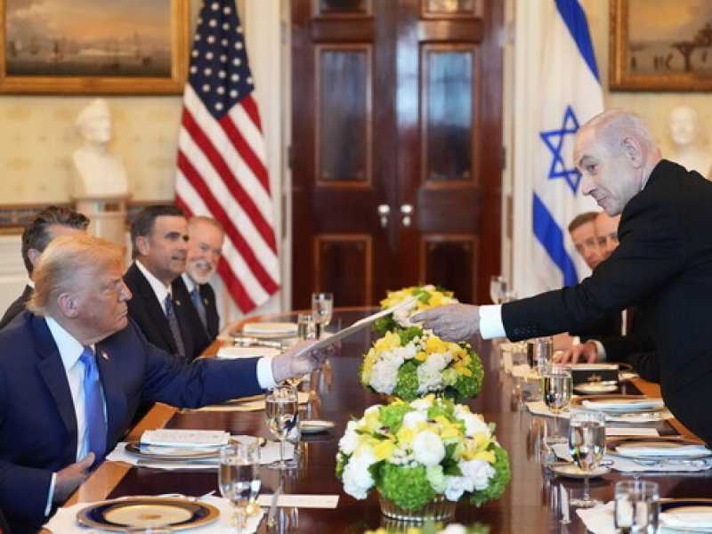 Benjamin Netanyahu consegna una cartella a Donald Trump durante l'incontro nella Sala Blu della Casa Bianca (foto Ap, via LaPresse)&nbsp;<br />