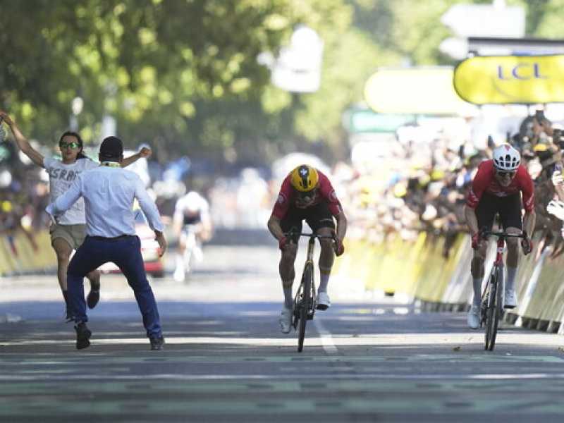 Jonas Abrahamsen, Mauro Schmid e un tizio che protestava per qualcosa sul rettifilo d'arrivo della undicesima tappa del Tour de France 2025 (foto Ap, via LaPresse) 