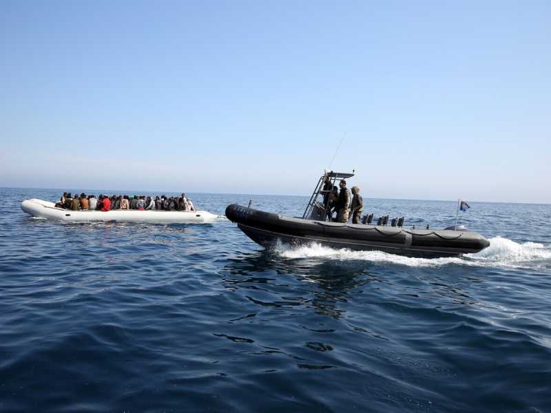 Un gommone della Guardia costiera libica intercetta un'imbarcazione di migranti (foto Getty)