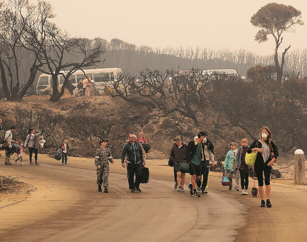 A sinistra l&rsquo;evacuazione di Mallacoota. A destra il primo ministro Scott Morrison a Sarsfield, nello stato di Victoria, il 3 gennaio scorso (Foto LaPresse)