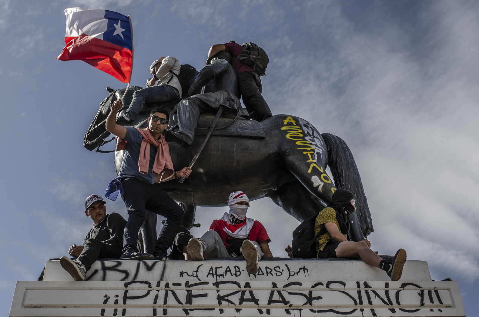 Manifestanti sotto al monumento equestre del generale Baquedano, a Piazza Italia, Santiago del Cile (foto di Indigo Prado)