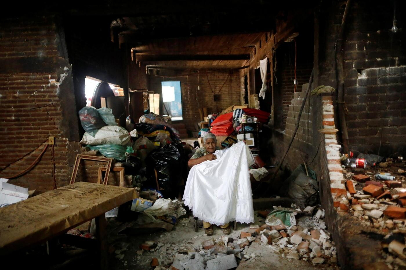 Justina Escamilla, 88 anni, &egrave; ritornata in casa per recuperare i suoi beni, qui &egrave; in posa con il suo abito da sposa all'interno della sua casa distrutta dopo il terremoto a San Juan Pilcaya, nella zona dell'epicentro