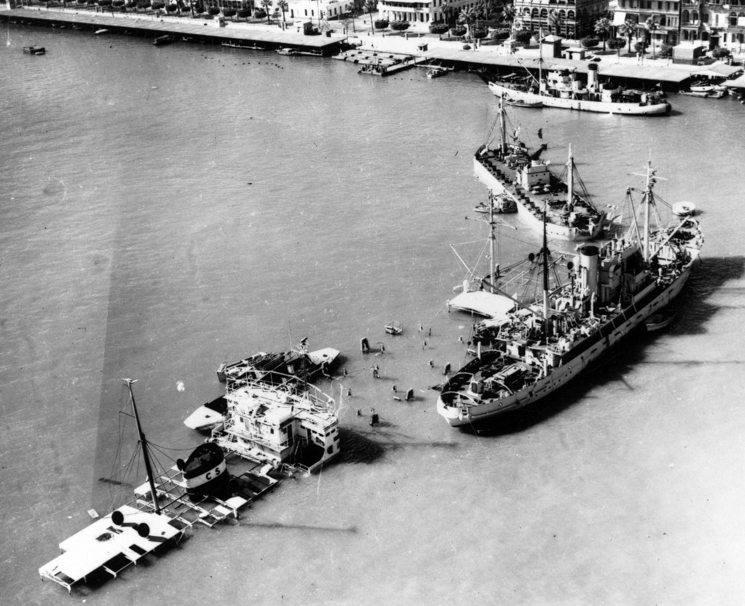 Una nave da salvataggio accanto a un relitto che blocca il Canale di Suez durante le operazioni di sgombero della via navigabile, nel novembre 1956 (Foto Getty Images)