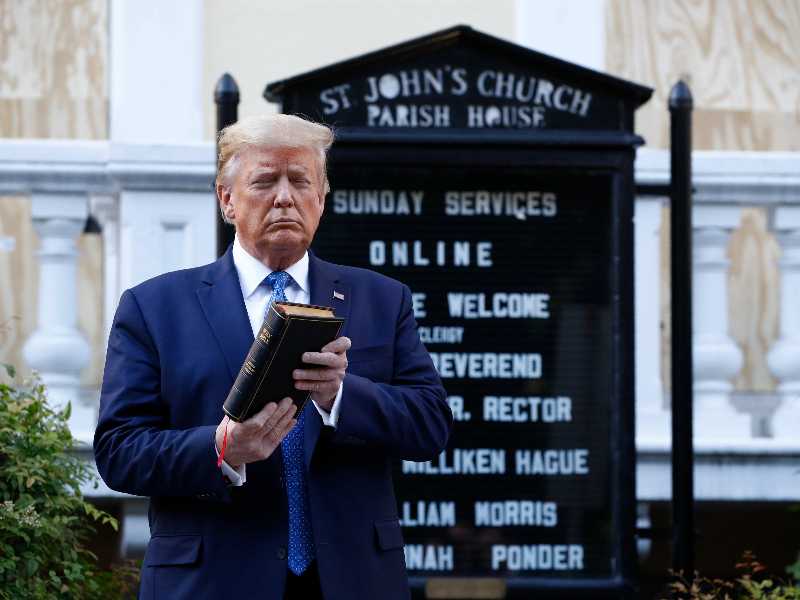 Donald Trump in preghiera, con Bibbia in mano, davanti ai fotografi