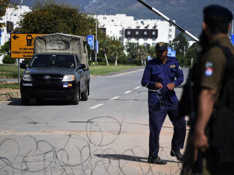 epa12904160 Pakistani security officials stand guard on a road leading to the Red Zone, where most diplomatic missions and government offices are located, including the venue for the expected second round of US-Iran peace talks, in Islamabad, Pakistan, 21 April 2026. As the ceasefire deadline nears, US negotiators are returning to Islamabad for a second round of talks, despite an Iranian Foreign Ministry spokesperson stating that Tehran has no plans to participate. EPA/SOHAIL SHAHZAD